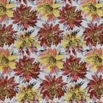 Flat view of ivory floral jacquard fabric with repeating oversized rust red, coral pink and golden yellow flowers, dark grey leaves and fine gold-toned detailing.