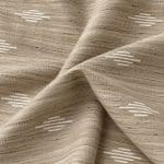 Sand-beige textured silk draped in overlapping folds, showing its irregular slub weave and small, pale champagne geometric motifs across the surface.