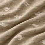 Close-up of sand-beige textured silk in soft diagonal folds, highlighting the irregular woven yarns and short champagne-white geometric stripes.