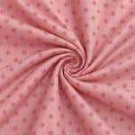 Soft pink silk jacquard gathered into a central spiral, with a repeating pattern of small brighter pink circular motifs and a smooth, light-catching surface.
