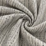 Off-white and midnight blue striped fabric gathered into a central spiral, showing raised yarns and narrow, irregular dark lines following the folds.