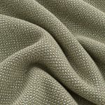 Close-up of sage green, ivory and beige textured linen draped in broad, overlapping folds, highlighting the raised woven threads and changing light across the surface.