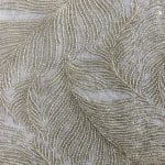 Extreme close-up of folded ivory chiffon with densely embroidered feather-like lines and small tonal sequins against the fine fabric ground.