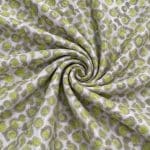 Silver-grey silk jacquard gathered into a central spiral, with lime green circular motifs and grey-green outlines radiating through the folds.